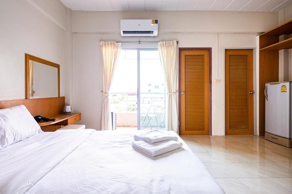 - une chambre avec un grand lit blanc et une fenêtre dans l'établissement GO INN v สนามบิน, à Lat Krabang