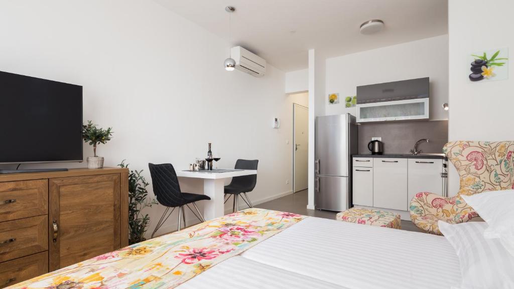 a bedroom with a bed and a kitchen with a tv at Bepo Studio Apartment - FREE PARKING in Split