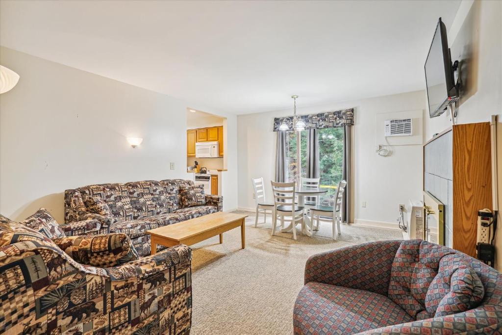 ein Wohnzimmer mit einem Sofa und einem Tisch in der Unterkunft Cedarbrook Deluxe Two Bedroom Suite with outdoor heated pool 10708 in Killington