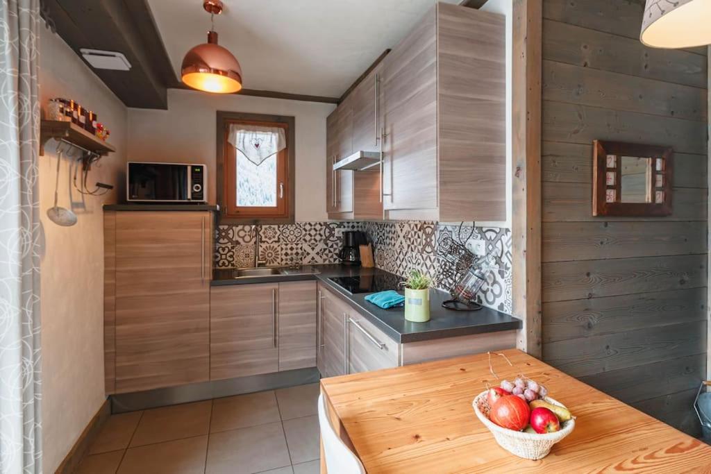 a kitchen with a table with a bowl of fruit on it at Chalet Bio Corti 6p. 3 ch proche pistes&#47;commerces in Champagny-en-Vanoise