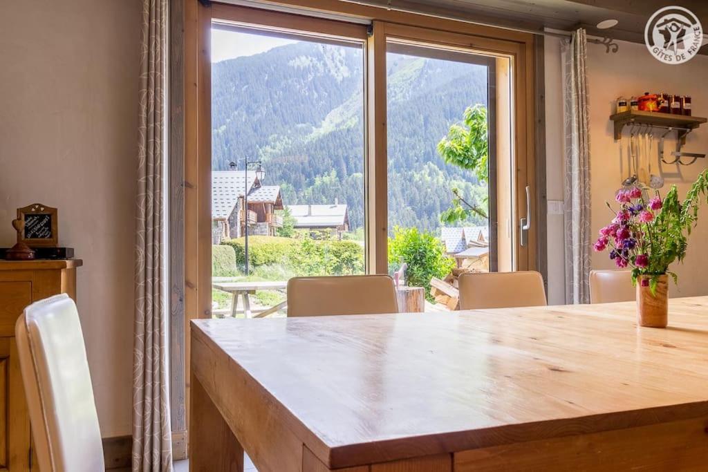 a dining room with a table and a large window at Chalet Bio Corti 6p. 3 ch proche pistes&#47;commerces in Champagny-en-Vanoise