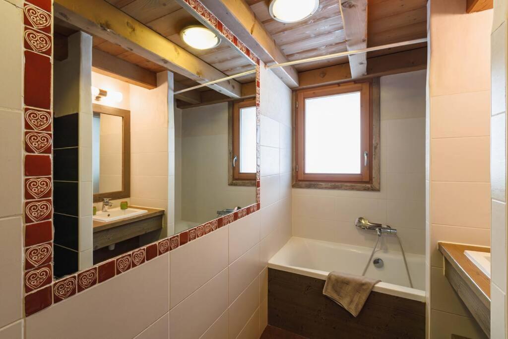 a bathroom with a tub and a sink and a mirror at Chalet Bio Corti 6p. 3 ch proche pistes&#47;commerces in Champagny-en-Vanoise