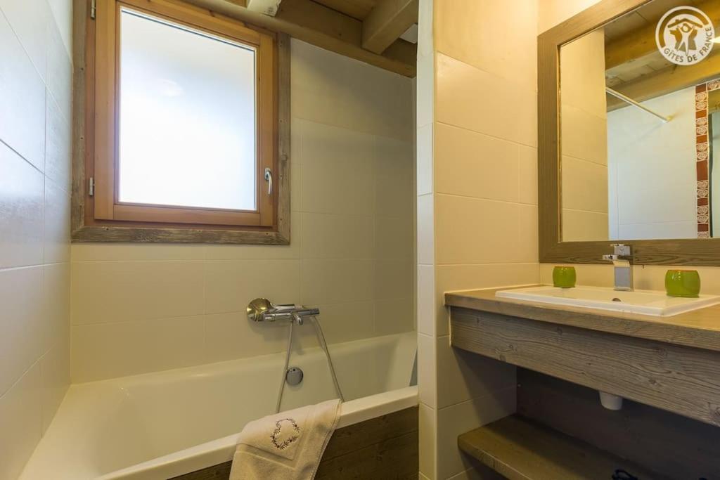 a bathroom with a sink and a tub and a mirror at Chalet Bio Corti 6p. 3 ch proche pistes&#47;commerces in Champagny-en-Vanoise