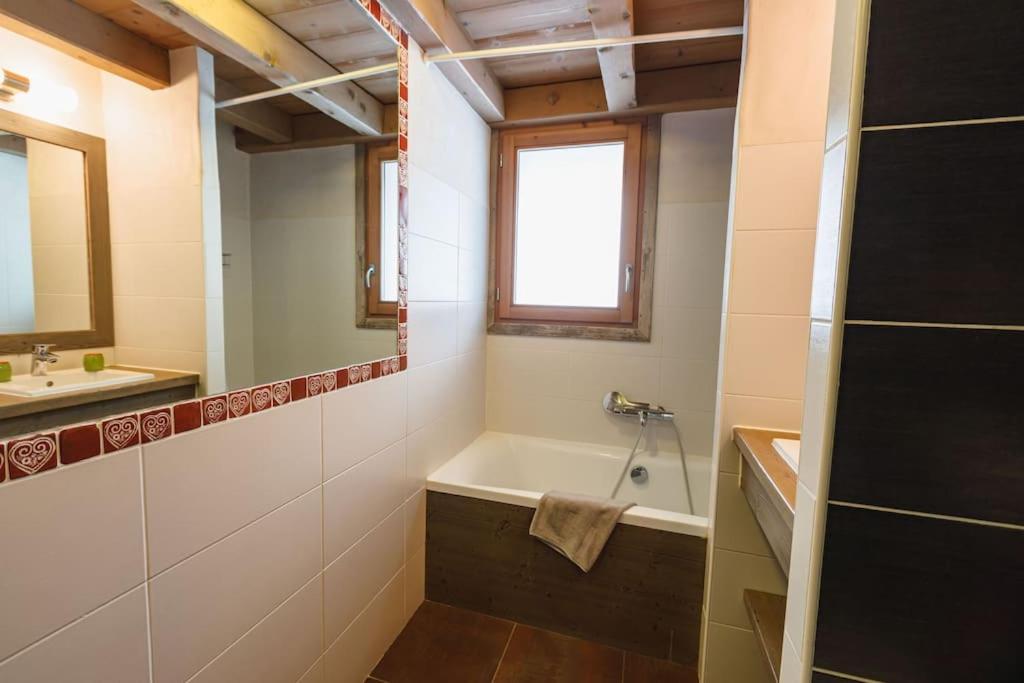 a bathroom with a bath tub and a sink at Chalet Bio Corti 6p. 3 ch proche pistes&#47;commerces in Champagny-en-Vanoise