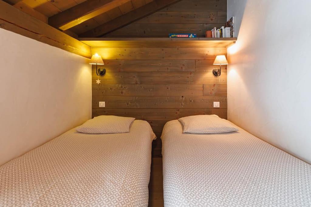 two beds in a small room with wooden walls at Chalet Bio Corti 6p. 3 ch proche pistes&#47;commerces in Champagny-en-Vanoise