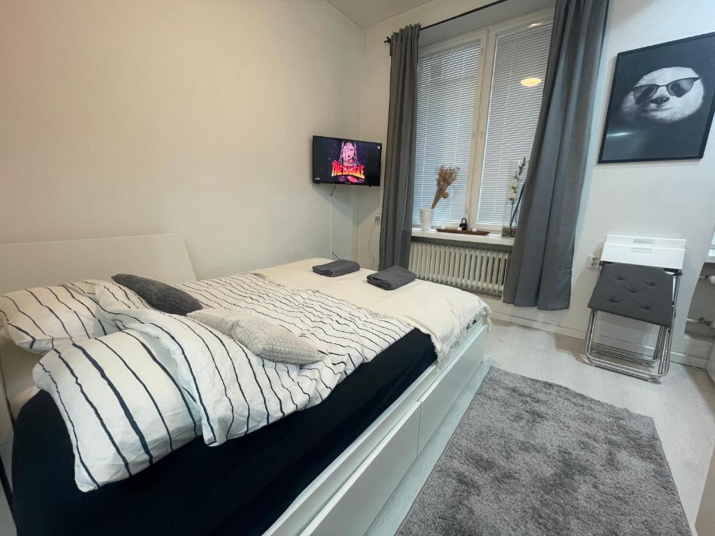 - un grand lit dans une chambre avec fenêtre dans l'établissement Cosy City Central Flat with self check-in, à Helsinki