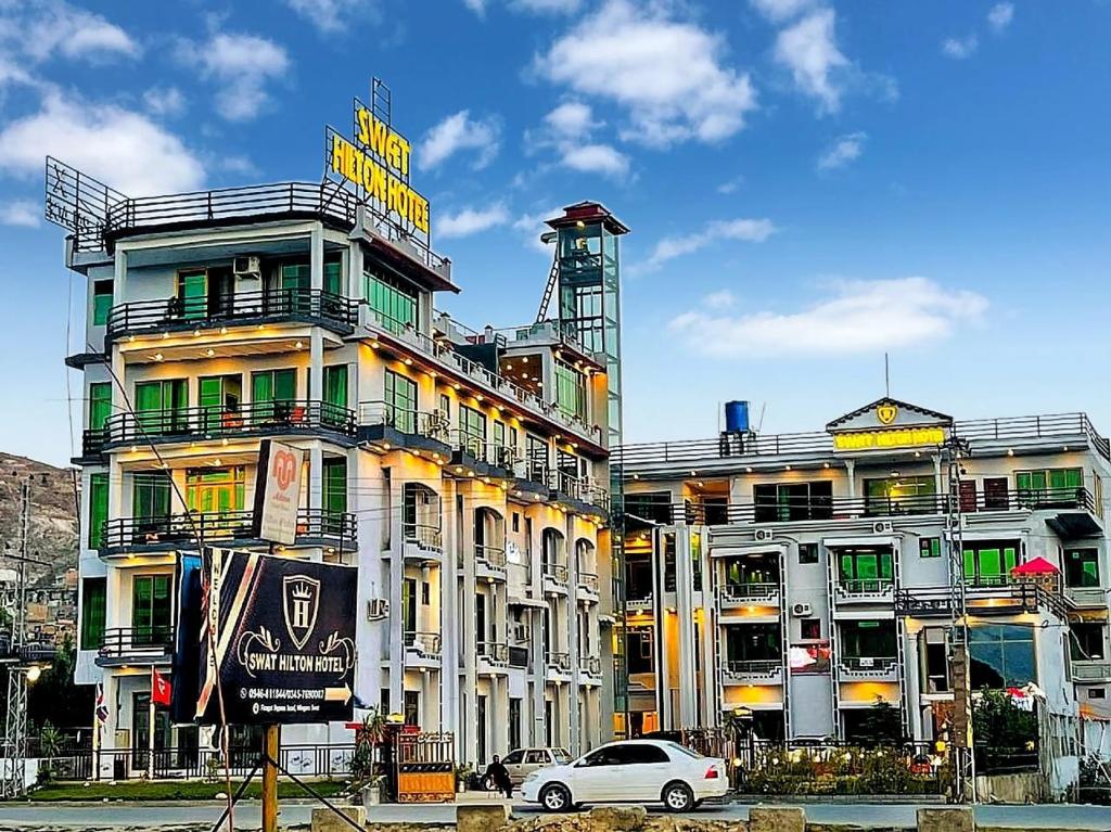 um edifício com um sinal na lateral em Swat Hilton Hotel by Khan Familia em Suat