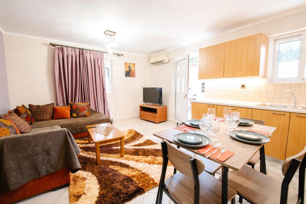 a living room with a couch and a table and a kitchen at Alexandros Apartments in Paralía Proastíou