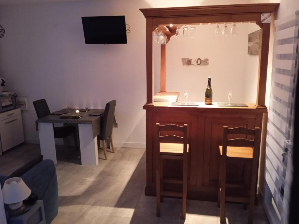 ein Wohnzimmer mit einem Tisch und einer Flasche Wein in der Unterkunft Capucine 