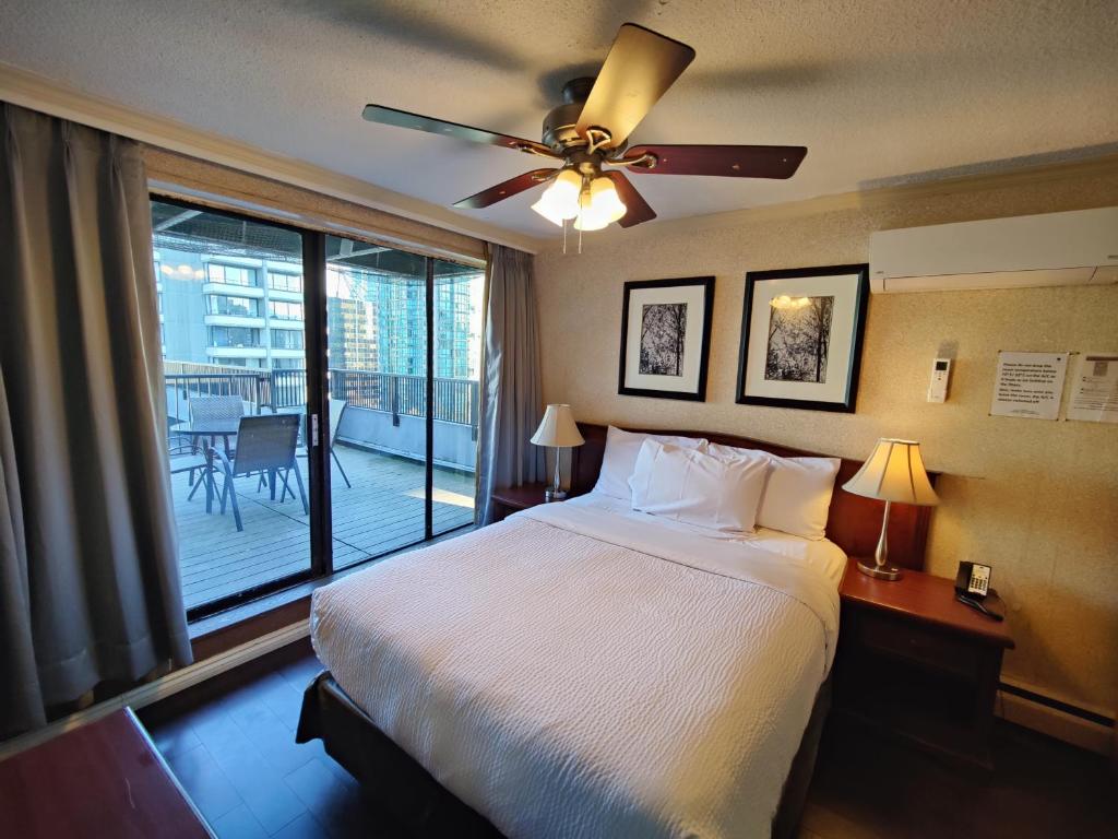 a bedroom with a bed and a ceiling fan at Divya Sutra Suites on Robson Downtown Vancouver in Vancouver