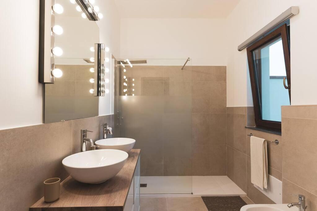 a bathroom with two sinks and a mirror at Cas'aPina apartment in Aci Bonaccorsi
