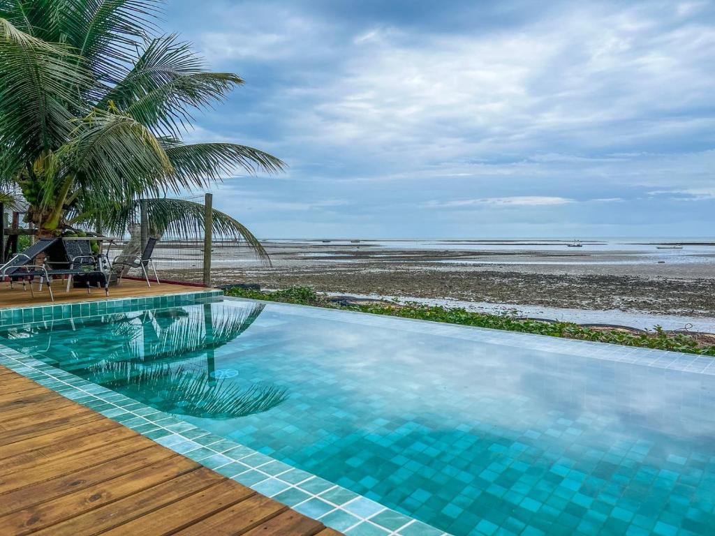a swimming pool with a view of the beach at Pousada Boa Sorte in Cumuruxatiba