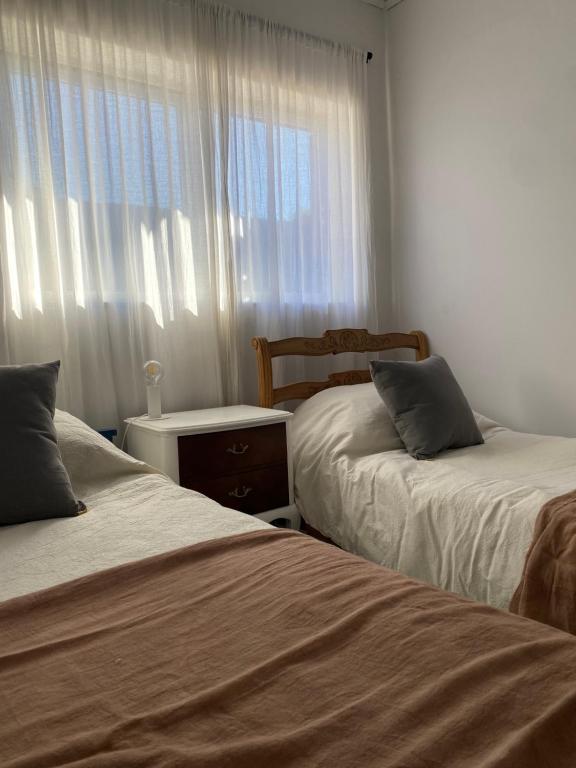 um quarto com 2 camas e uma janela em Casa Hornos - Alquiler temporal em Olavarría