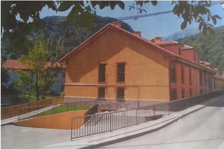 um edifício com uma cerca em frente em Apartamento en picos de europa em Carreña de Cabrales