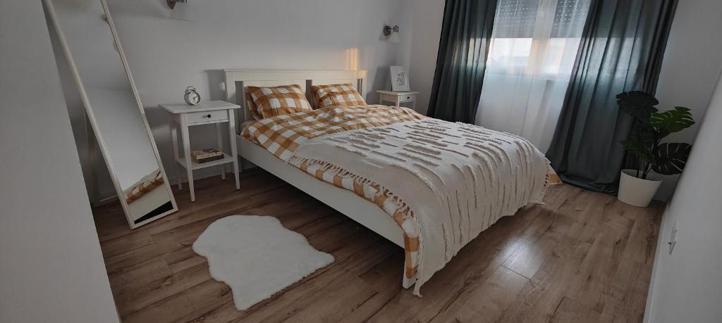 a bedroom with a large bed and a wooden floor at Arad Central Residence in Arad