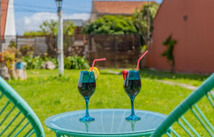 dos vasos de vino sentados en una mesa en un patio en Casita con parque,a 2 cuadras de la playa en Mar del Plata