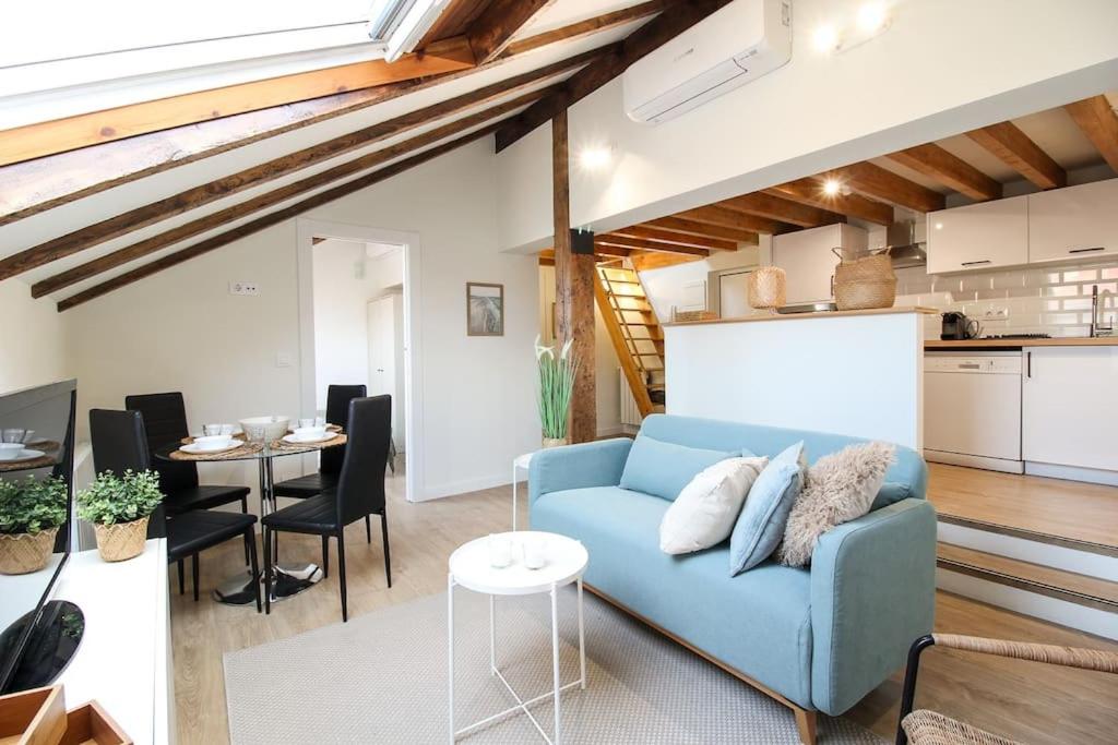 ein Wohnzimmer mit einem blauen Sofa und einem Tisch in der Unterkunft Designer duplex in the center in Santander
