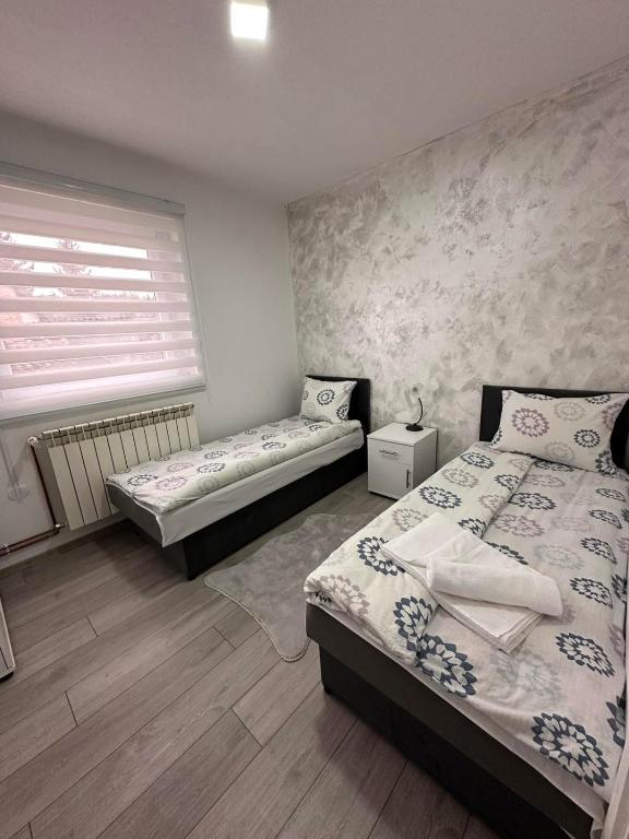 a bedroom with two beds and a window at Apartman ALEA in Pale