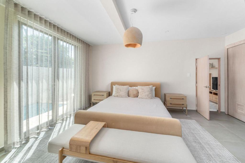ein Schlafzimmer mit einem Bett und einem großen Fenster in der Unterkunft Casa Loba Luxe Unit 1 with private swimming pool in Rincon