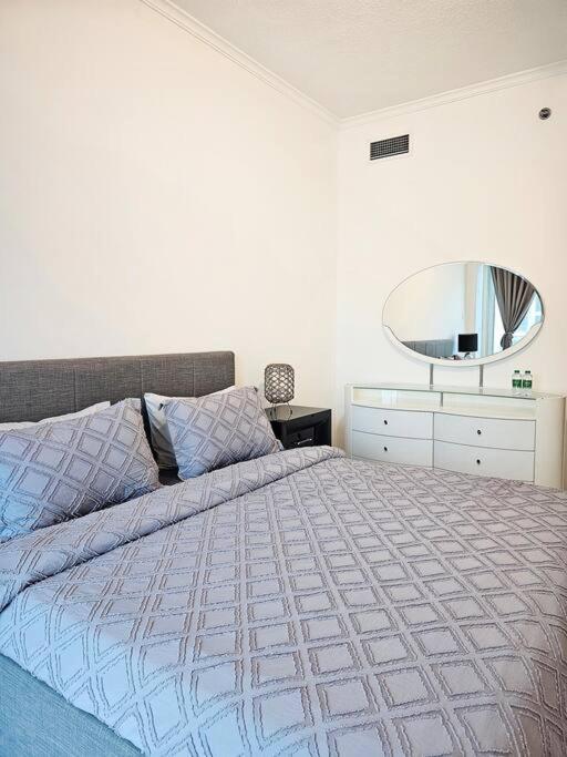 een slaapkamer met een groot bed en een spiegel bij Luxury Botanica Apartment 268 in Dubai