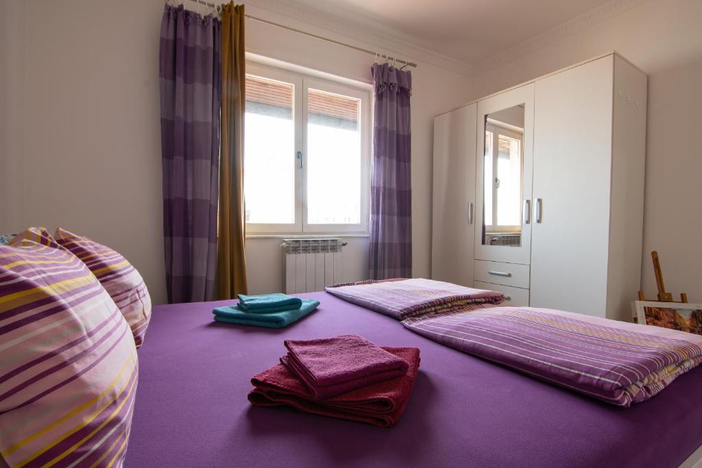 a bedroom with two beds with purple sheets and towels at The best location in town 65m2 in Belgrade