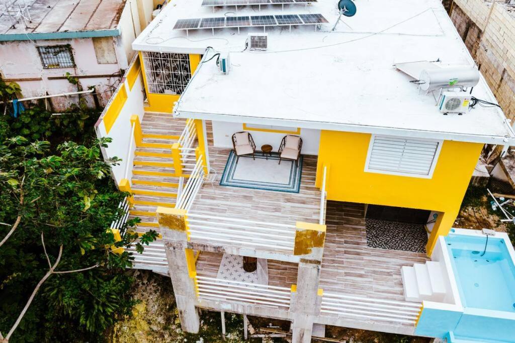 una vista aérea de una casa amarilla con terraza en Panoramic Escape with Private Pool, en Mayagüez