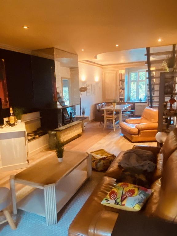 un salon avec un canapé et une table dans l'établissement LA MARIEFACTURE - Comme à la Guinguette !, à Hombourg-Haut