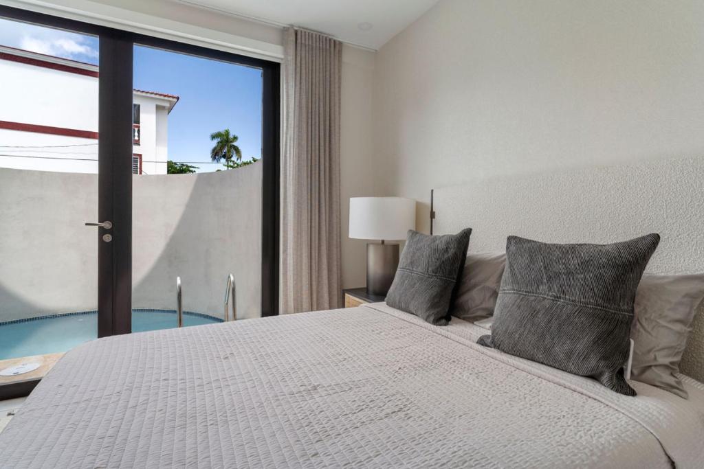 a bedroom with a large white bed with a window at Casa Loba Luxe Unit 3 with private pool in Rincon