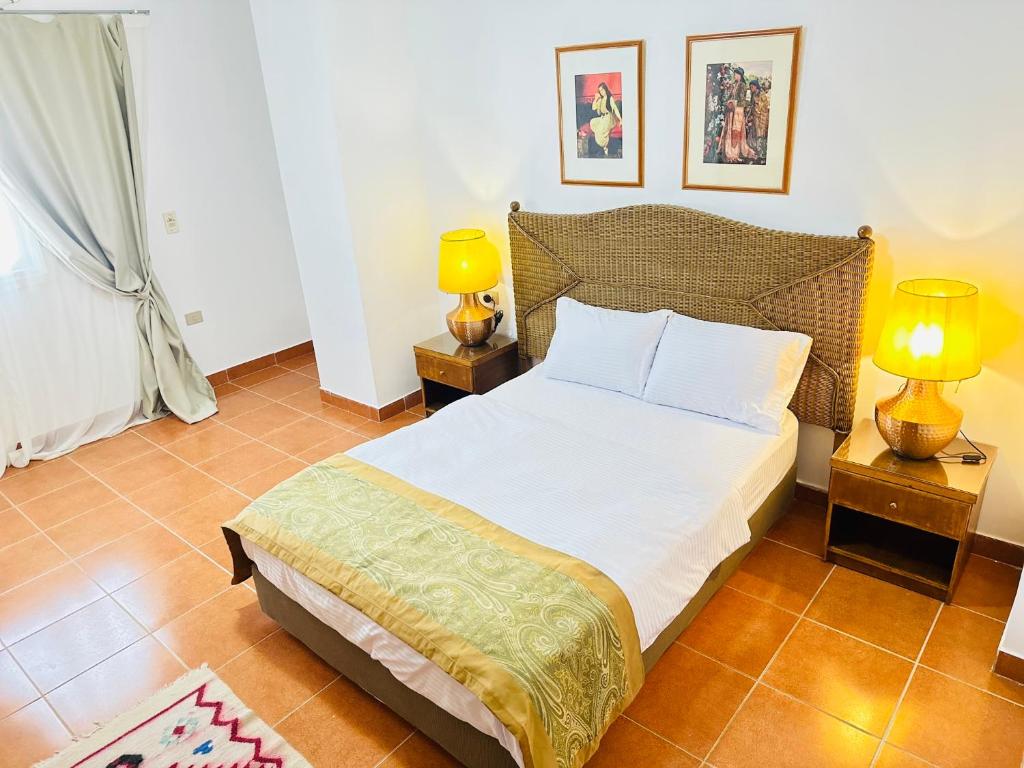 a bedroom with a bed and two lamps on tables at Casa Do Cairo-Sharm Alsheikh in Sharm El Sheikh