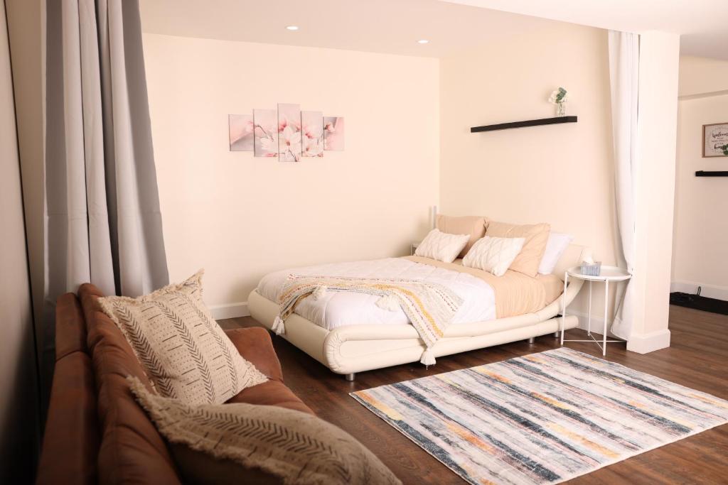 a bedroom with a white bed and a couch at bedford - Urban escape in Montreal