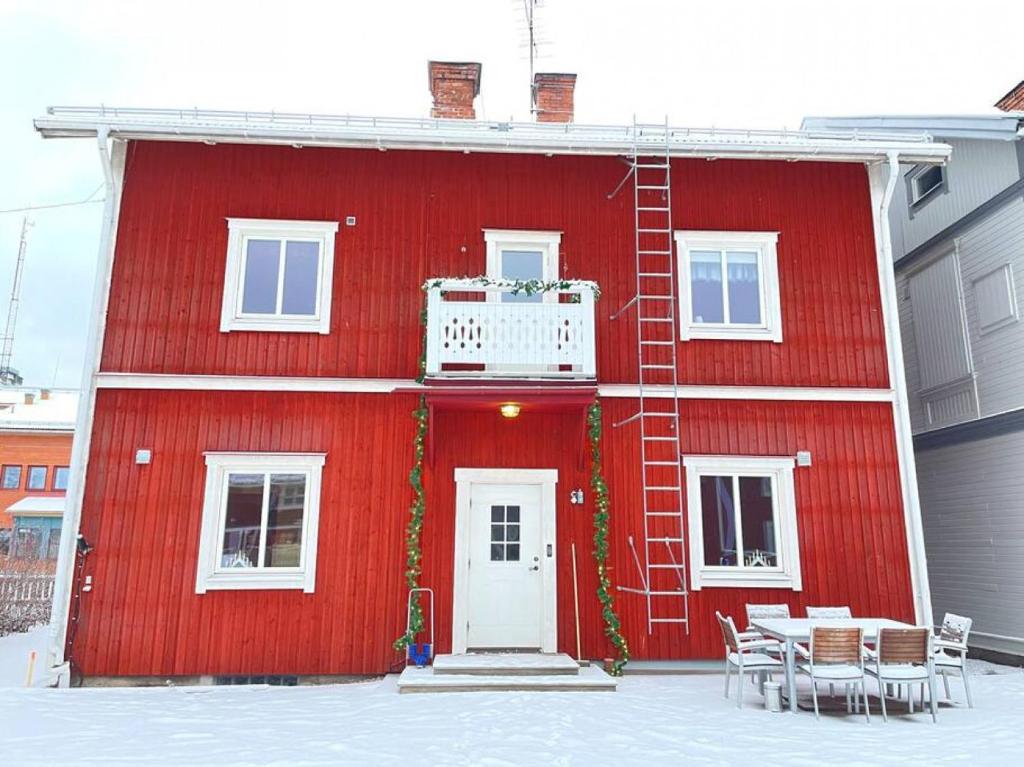 a red house with a table and chairs in front of it at Skraddaren, close to Vasaloppet finish line portal in Mora