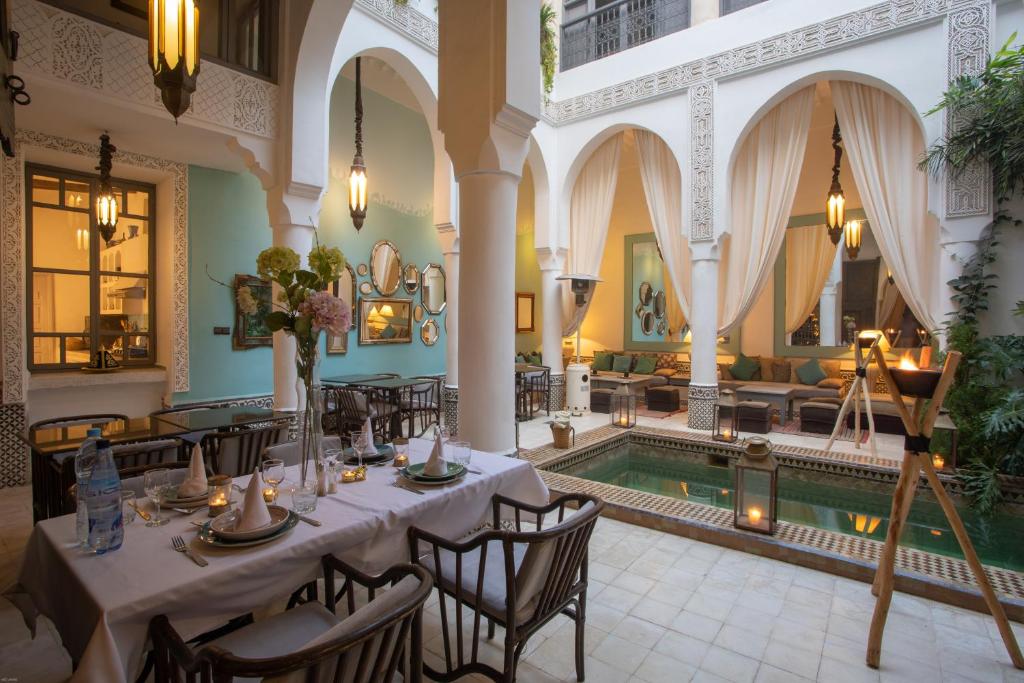 a dining room with a table and a swimming pool at Riad Dar Saad - Hammam & Spa in Marrakesh