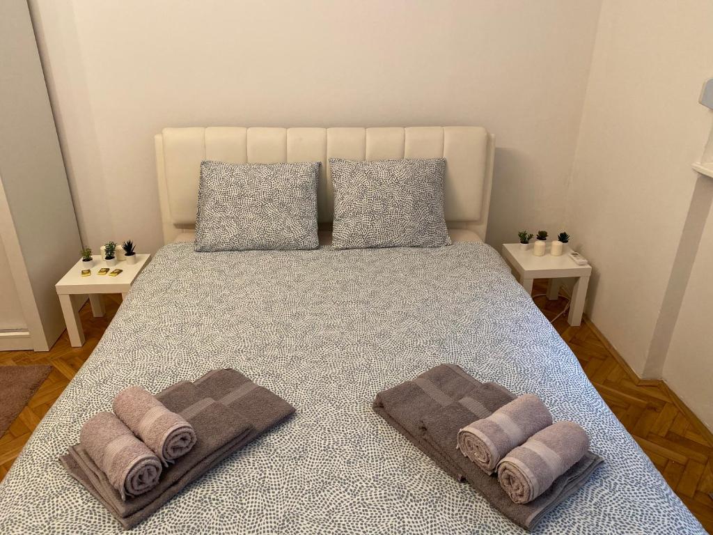 a bedroom with a bed with towels on it at Apartment Tilia Center Belgrade in Belgrade