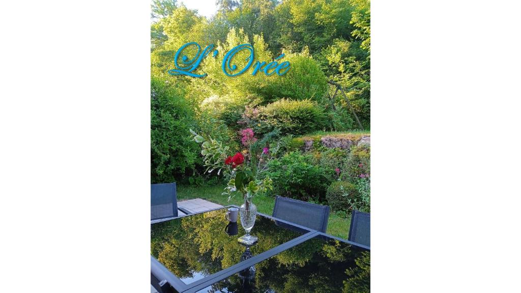 a garden with a table and a sign that reads of one at L'Orée in Verneuil-en-Halatte