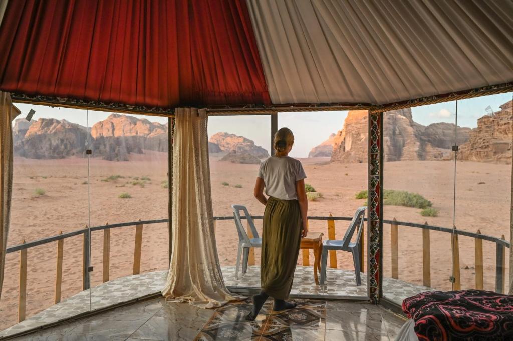 a man standing in a tent looking out at the desert at Joy to Wadi Rum in Wadi Rum