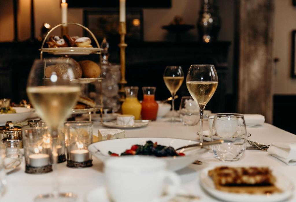 stół z kieliszkami wina i jedzeniem na nim w obiekcie Cobergher Hotel w mieście Kortrijk