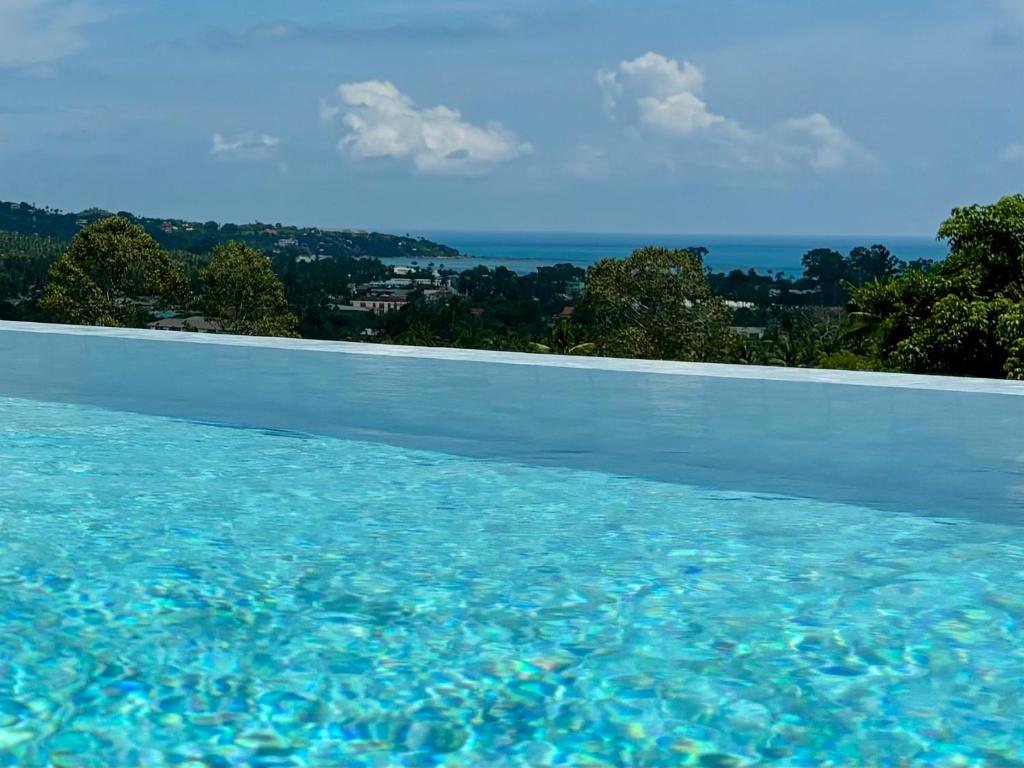 a swimming pool with a view of the water at VILLA CLARISSE - SEAVIEW - 4 Bedrooms in Koh Samui 