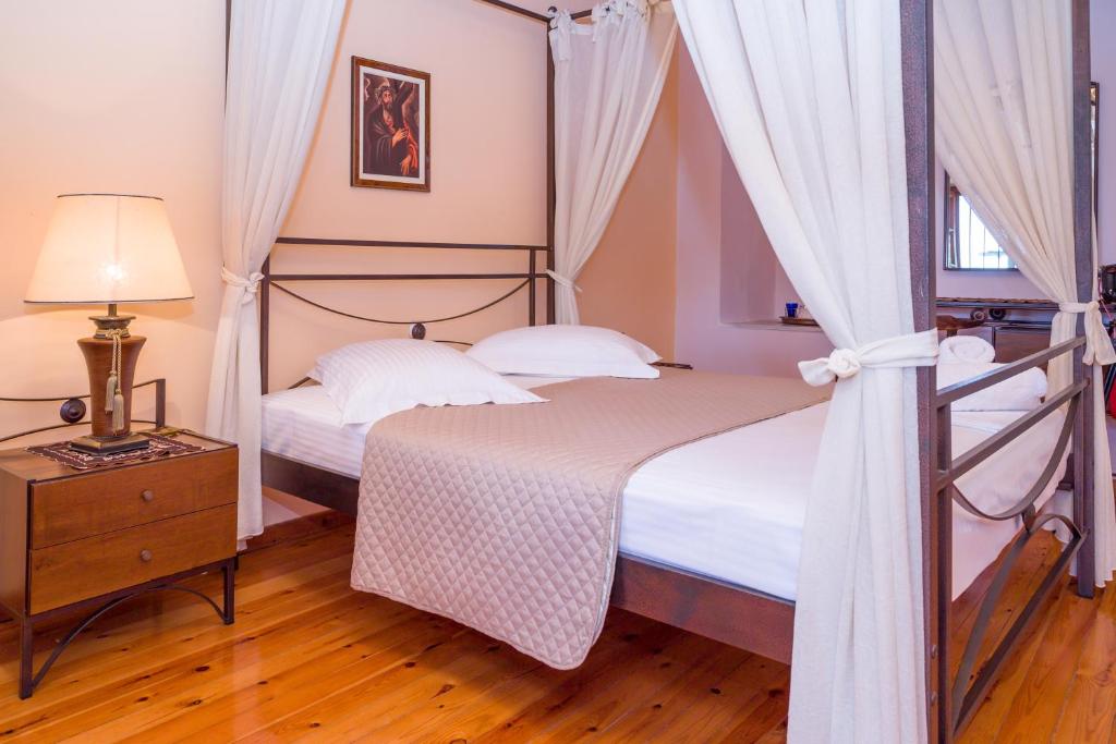 sypialnia z 2 łóżkami i lampką na drewnianej podłodze w obiekcie VILLA - APA w mieście Gythio