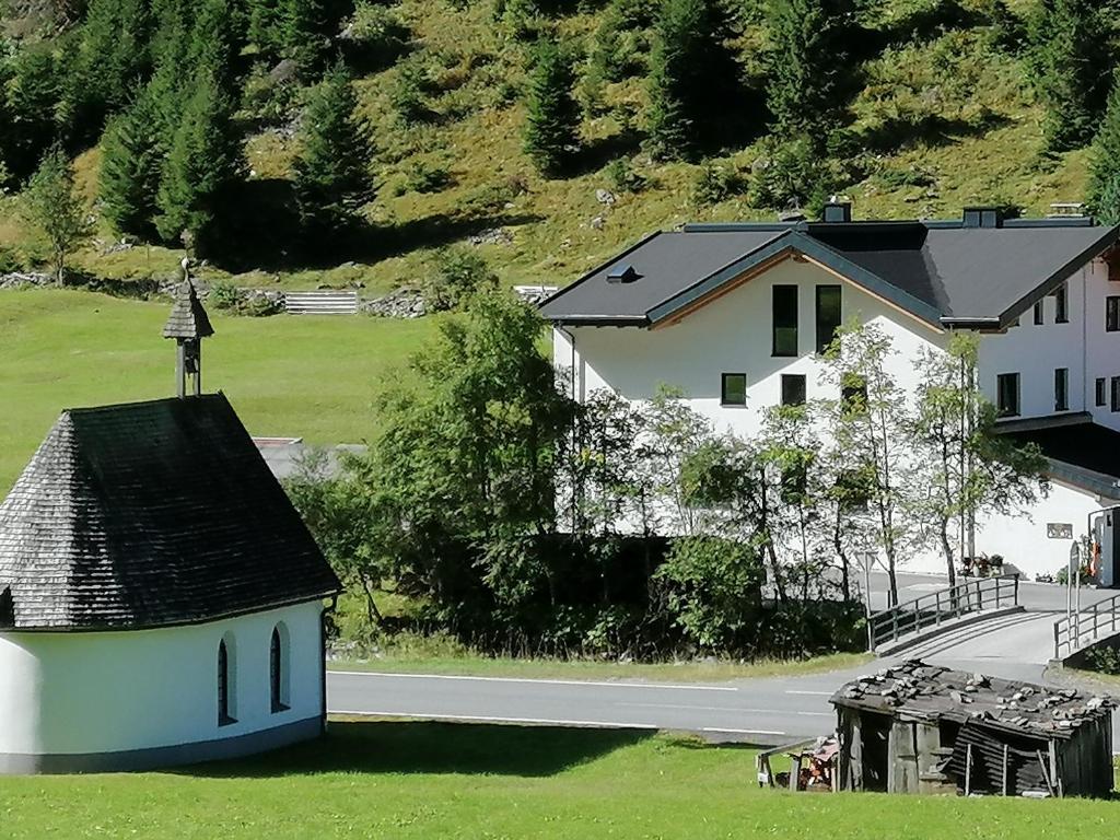 a church with a cross on top of a house at Haus Larcher Appartment in Sankt Leonhard im Pitztal