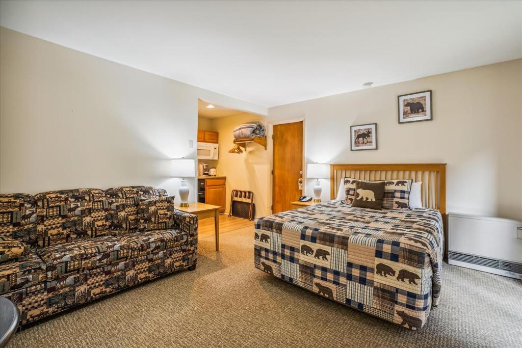 a bedroom with a bed and a couch at Cedarbrook Queen Studio 107 in Killington