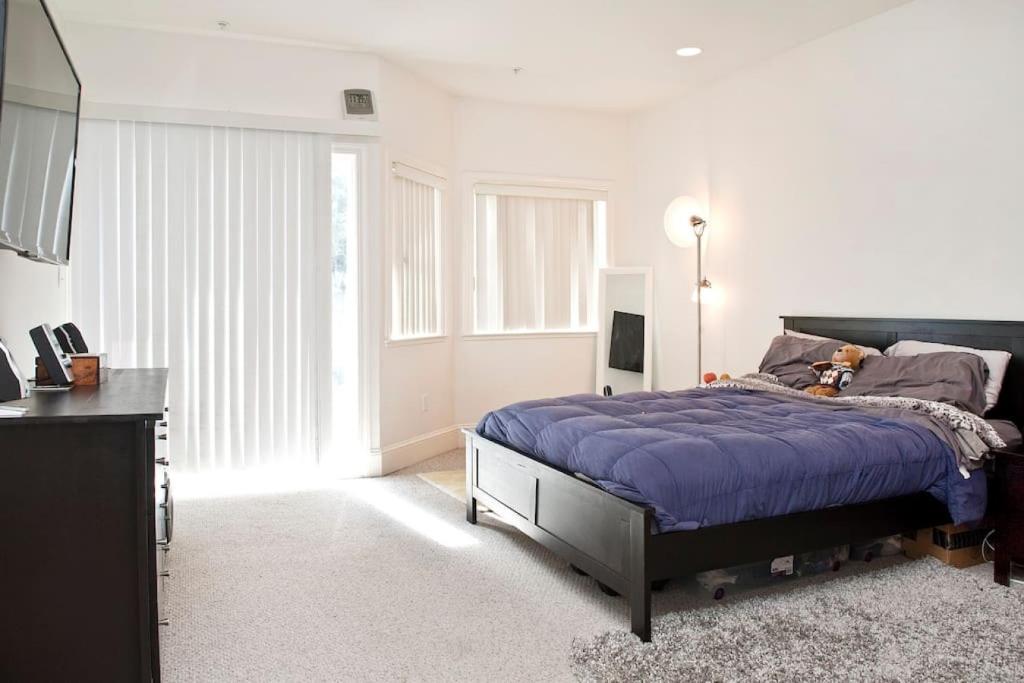 a bedroom with a bed with a blue comforter at HUGE Open Concept Living in Best Location in San Francisco