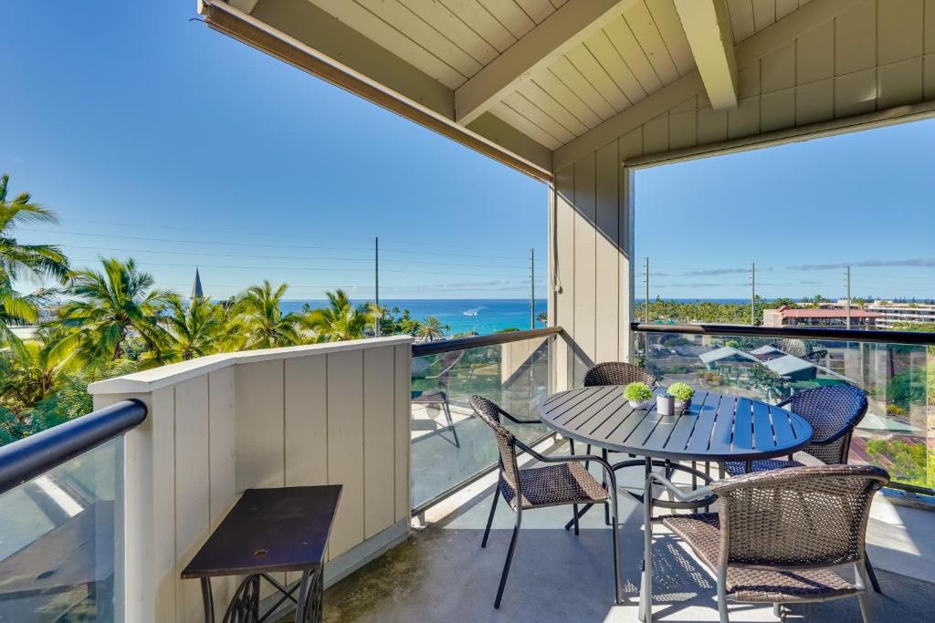 a balcony with a table and chairs and a view of the ocean at Top-Floor Kailua Bay Resort Condo with Ocean Views! in Kailua-Kona