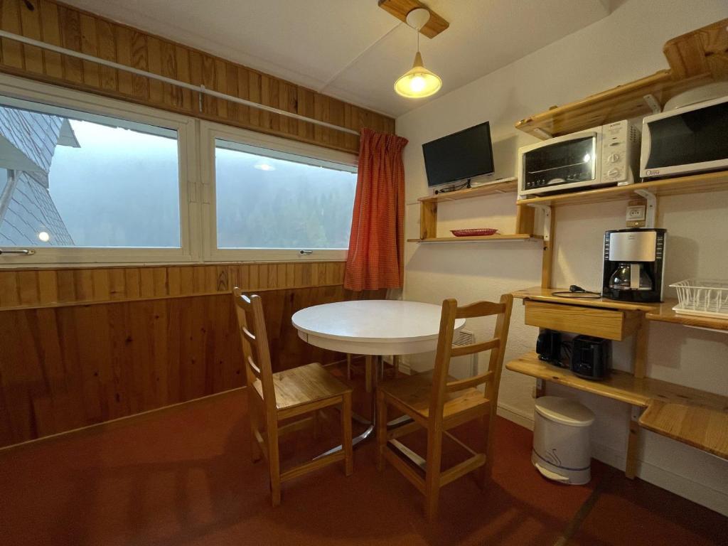 une petite cuisine avec une table et des chaises ainsi qu'une fenêtre dans l'établissement Studio Économique pour 2 pers, Pied des Pistes - Les Menuires (Animaux Acceptés) - FR-1-452-288, aux Menuires