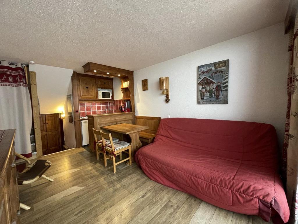 - une chambre avec un lit rouge et une table dans l'établissement Studio duplex 4 personnes avec balcon, Brelin, Les Menuires - FR-1-452-151, aux Menuires