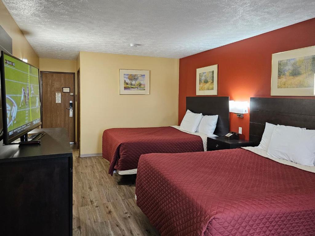 Habitación de hotel con 2 camas y TV de pantalla plana. en Budgetel inn & Suites, en Fort Scott