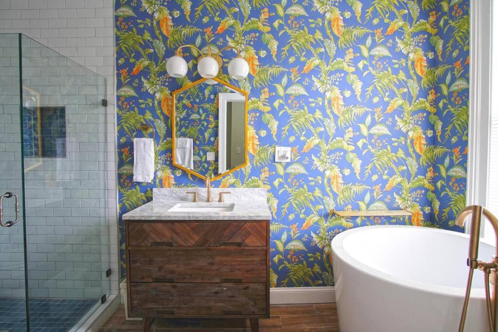La salle de bains est pourvue d'une baignoire, d'un lavabo et d'un miroir. dans l'établissement Carriage House on Chatham Sq, à Savannah