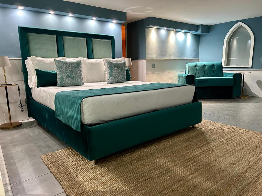 een slaapkamer met een groot bed en een bank bij A un passo dal Castello Maschio ANGIOINO Appartment in Napels