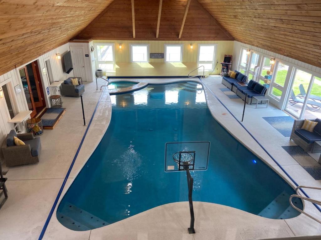 an indoor pool with a basketball hoop in a house at Indoor Pool Near Grand Haven & Lake Michigan Beach in Spring Lake