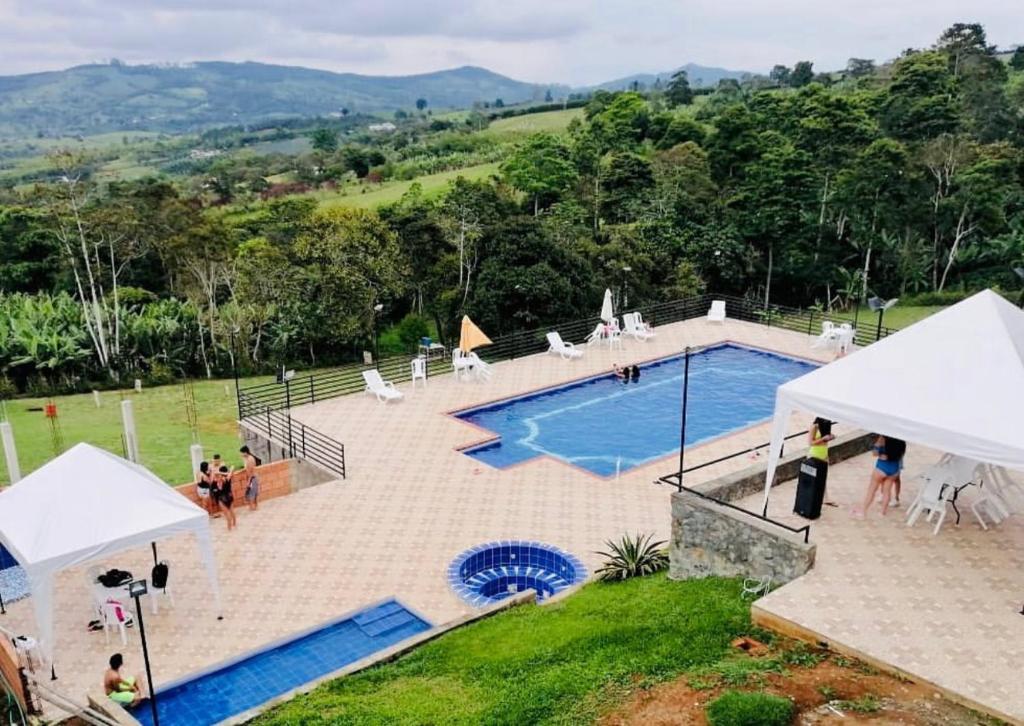 una gran piscina con gente a su alrededor en Buen Vivir Restrepo a 30 minutos Lago Calima en Restrepo