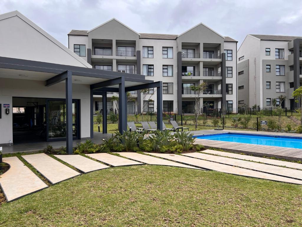 an apartment building with a swimming pool in front of it at Ultra Modern Apartment - Self Catering in Ballito